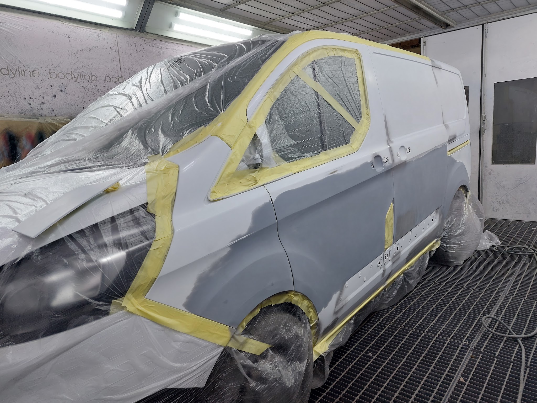Van masked with tape and film, panels in primer