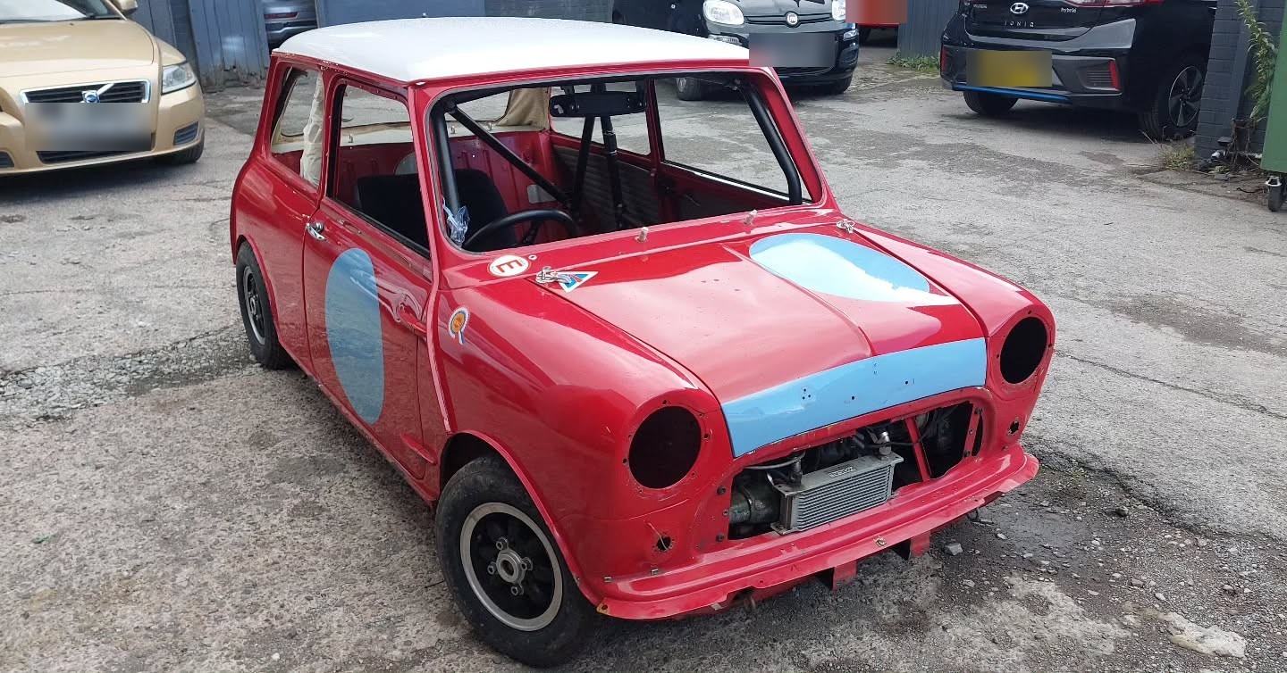 Red 1964 Mini Cooper ex track car with a roll cage, on arrival